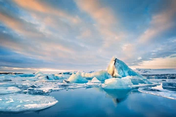 Poster Im Rahmen Icebergs float on Jokulsarlon glacier lagoon at sunrise, in Iceland. © mandritoiu