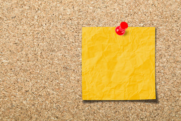 Blank sticky note on cork board