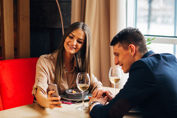 Happy young couple taking selfie with smart phone at cafe