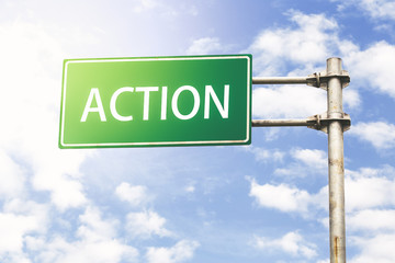 Action Road Sign Against Blue Sky