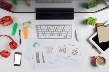 Office desk table with keyboard,calculator,pencil,mouse,smart phone,financial data or chat or graph and cup of coffee.Flat lay photo.