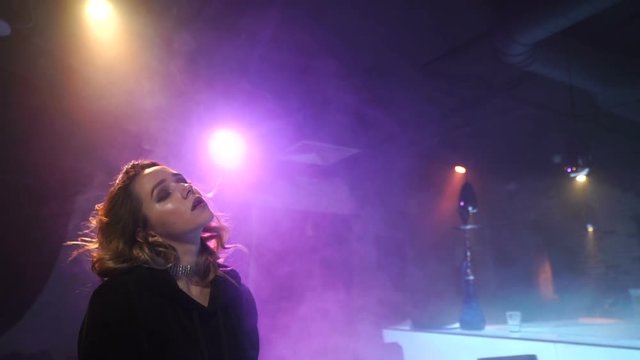 Sensual girl is amid the clouds of smoke