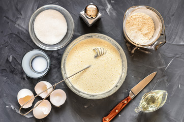 cooking  of Russian dishes pancakes: eggs, milk, flour, butter, salt. Top view