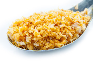 Deep fried garlic  ingredients in a spoon close up on white background