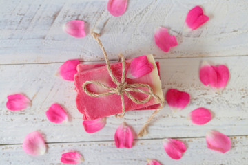 Soap with Rose Extract.Handmade soap with rose extract and rose petals on  wooden plank background. Organic Vegetable Cosmetics Concept.vegan soap with rose fragrance