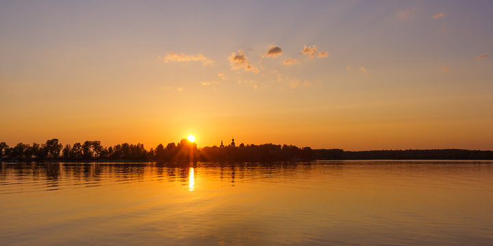Sun over the church at sunset on Lake Seliger