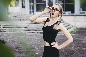 slender girl in black dress with pigtails and glasses