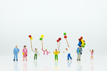 Miniature people: Childrens holding a balloon. Image use for background International day of families concept.