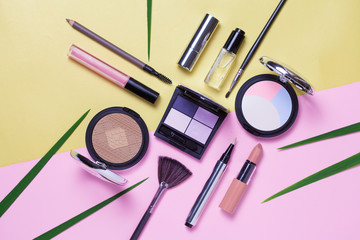 Beauty, decorative cosmetics. Makeup brushes set and color eyeshadow palette on pink and golden background , flat lay, top view, Minimalistic style