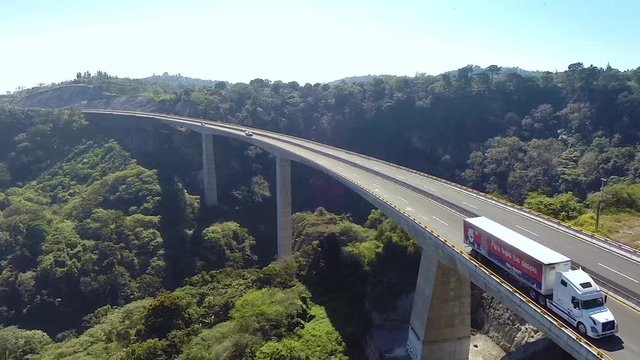 Aerial 360 shot of a causeway in the middle of the forest with a big bus on it in Mexico