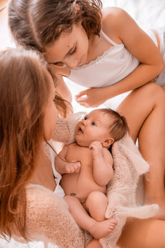 Older Sister Holding A Newborn Baby.