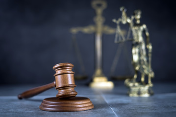 Law and Justice concept. Mallet of the judge, books, scales of justice. Gray stone background,...
