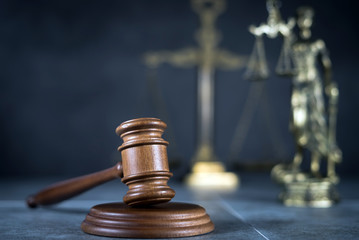Law and Justice concept. Mallet of the judge, books, scales of justice. Gray stone background,...