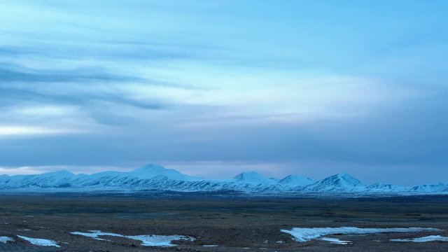 time lapse of cold steppe in tibet plateau and snow mountain at dusk, Qinghai Hoh Xil nature reserve, China