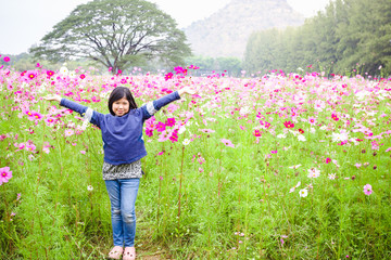 Portrait beautiful happy young girl enjoying smell in a cosmos flowering spring garden © kasipat