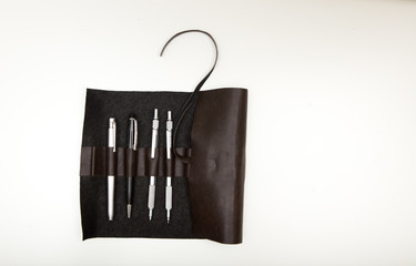 A roll up pencil holder made of faux leather