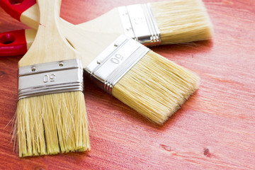 House renovation, paintbrushes on the old wooden background