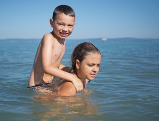 Little girl and littel boy playing in water