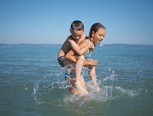 Little girl and littel boy playing in water