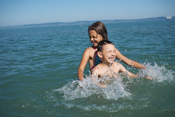 Little girl and littel boy playing in water