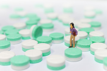 miniature woman people standing in the midst of pills