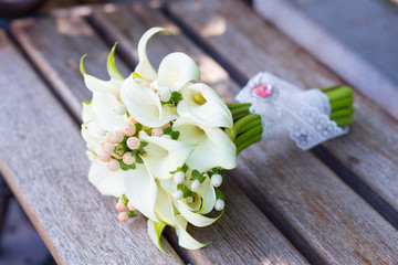 Beautiful wedding bouquet of white callas on the bench