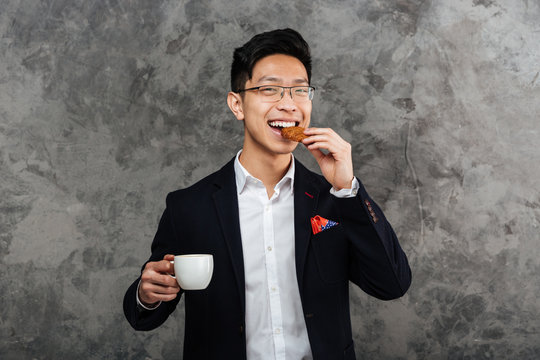 Portrait Of A Smiling Young Asian Man Dressed In Suit