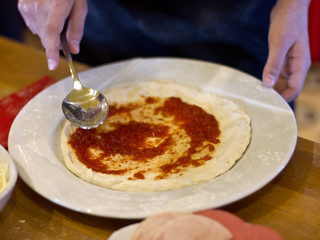 The cook is making pizza. Tomato sauce for dough