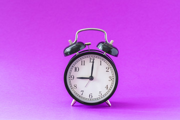 Black modern alarm clock set at nine o'clock, isolated, work school begins concept, ultraviolet background