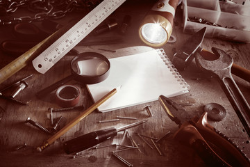Workbench with notebook and pencil in sepia tone