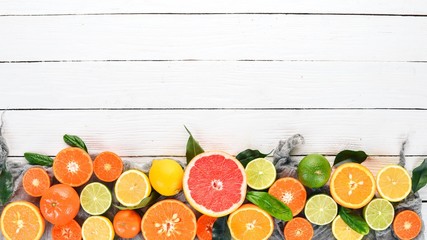 A set of citrus fruit. Orange, tangerine, grapefruit, lemon. On a wooden background. Top view. Copy...