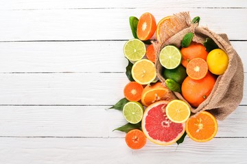 A set of citrus fruit. Orange, tangerine, grapefruit, lemon. On a wooden background. Top view. Copy space.