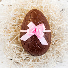 Chocolate Easter eggs on white wooden background. 