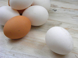 A lots of white and brown chicken eggs close-up on shabby background