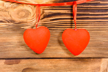Two red hearts on a wooden background. Top view