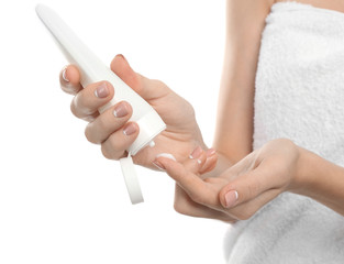 Young woman applying hand cream on white background, closeup