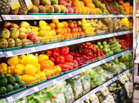 Shelves with fresh vegetables and fruits in supermarket