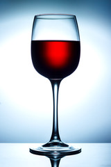 Red wine on a skylight with reflection on a blue background