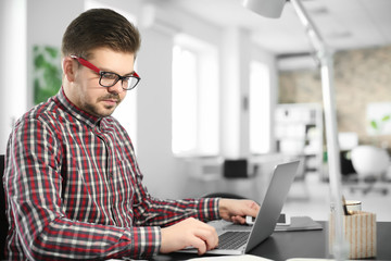 Young man with laptop working in office