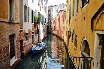 Fototapeta na wymiar A Venetian canal with docked boats. Venice, Italy