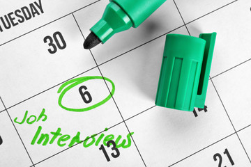 Color marker and calendar with date reminder about job interview, closeup