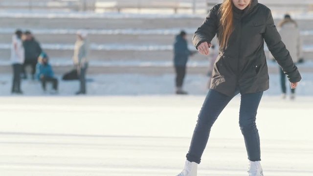 Russian teenager girl skillfully skating and spending time on public ice rink