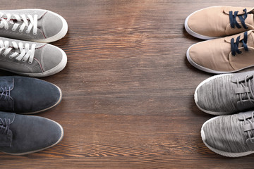 Different male shoes on wooden floor