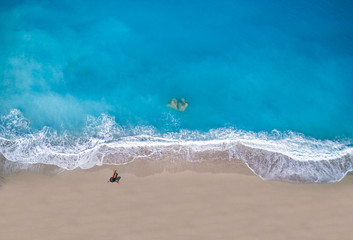 Top view of a woman at the tropical beach relaxing on the sand