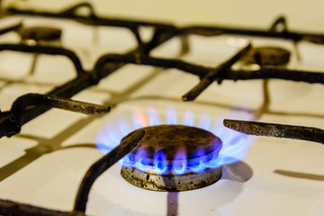 Gas burner on the white kitchen stove