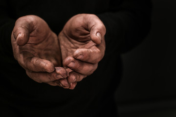 Poor man begging for money on dark background