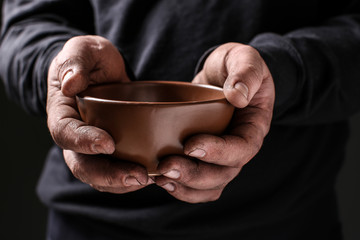Poor man with bowl begging for money, closeup