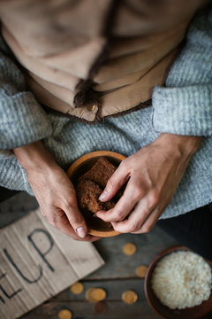 Poor woman holding bowl with bread, closeup
