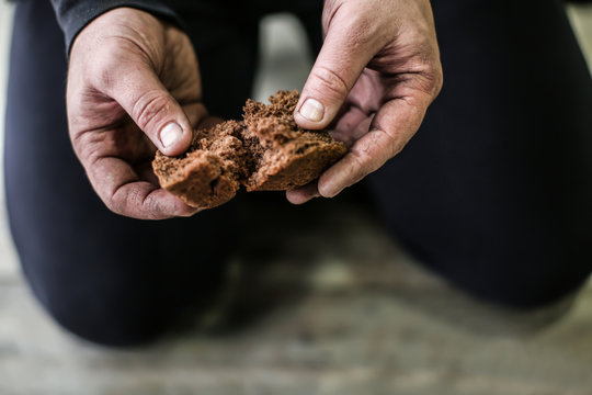 Poor man holding bread, closeup