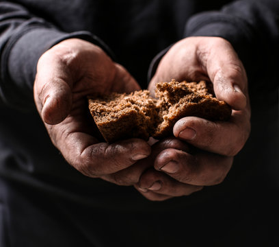 Poor man holding pieces of bread, closeup